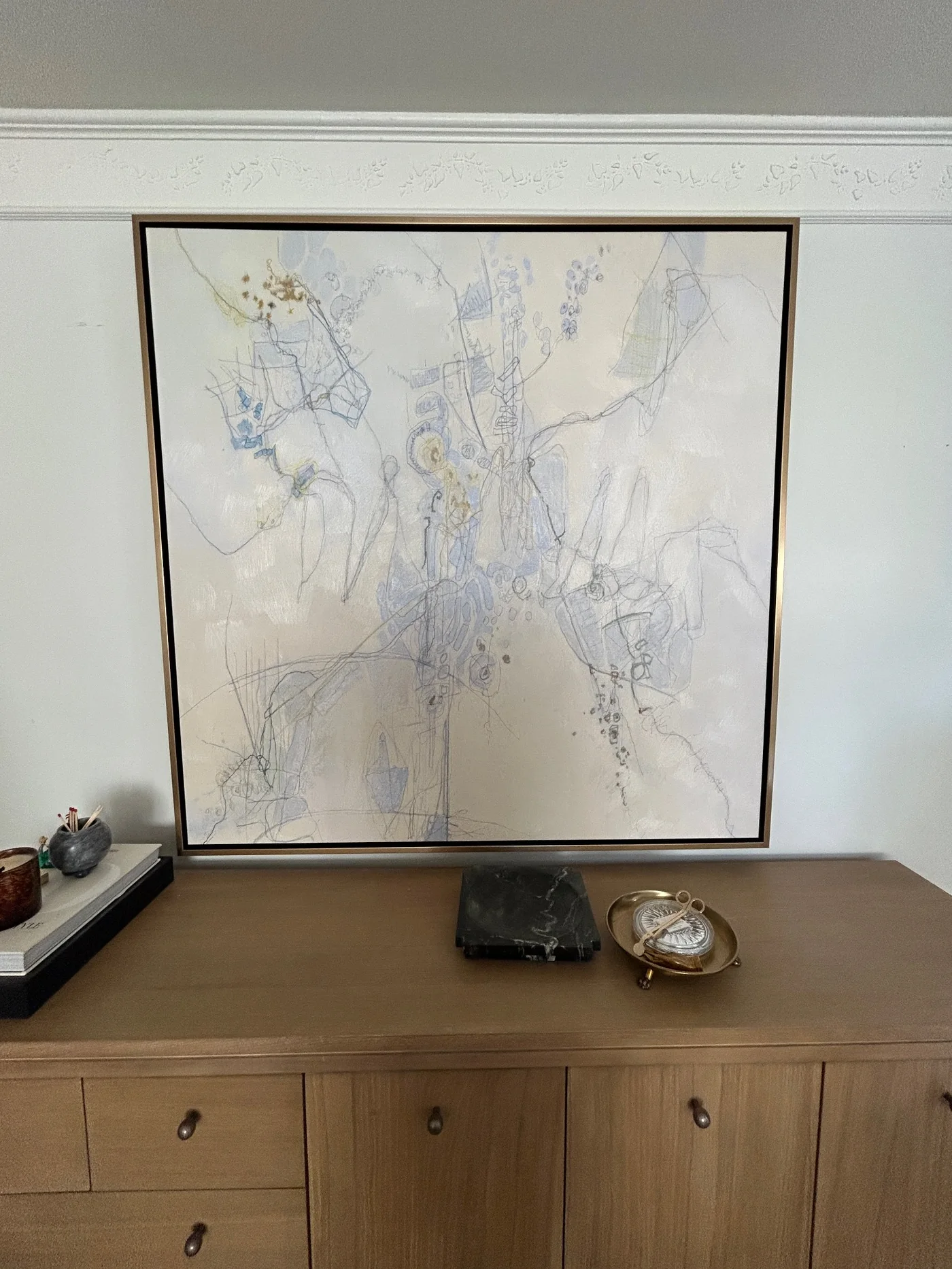 Large abstract artwork installed above a cabinet